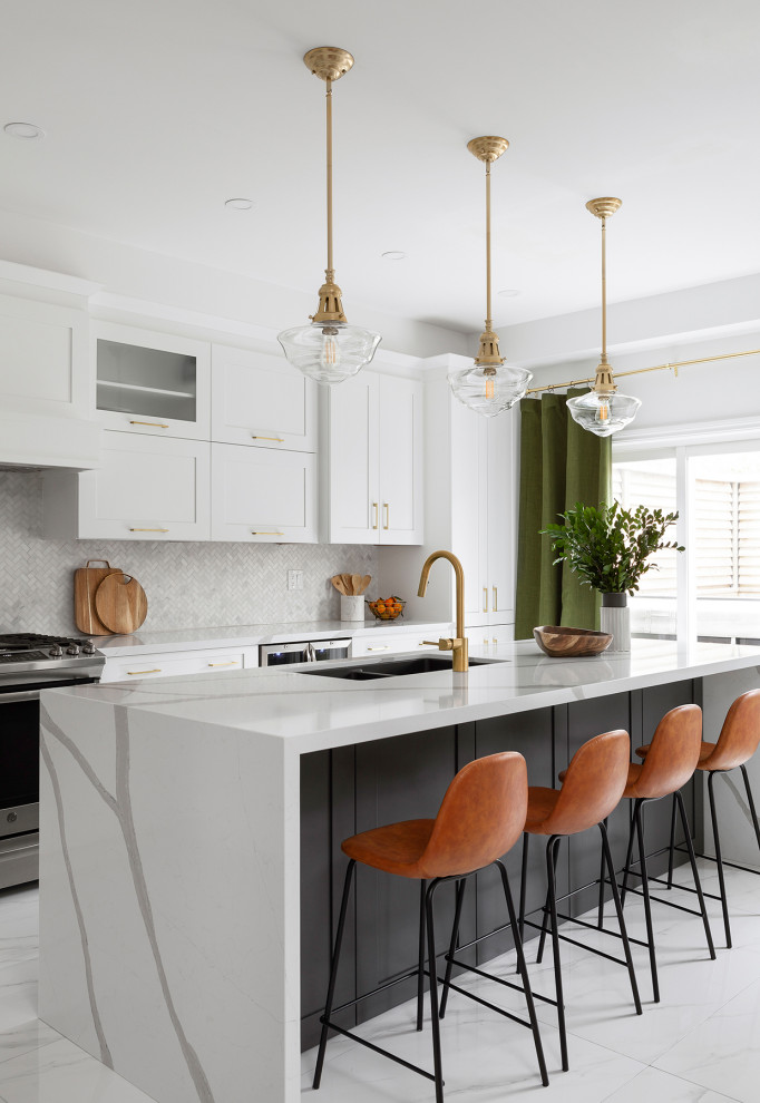 This is an example of a mid-sized contemporary open plan kitchen in Toronto with an undermount sink, shaker cabinets, grey cabinets, quartz benchtops, white splashback, marble splashback, stainless steel appliances, porcelain floors, with island, white floor and white benchtop.