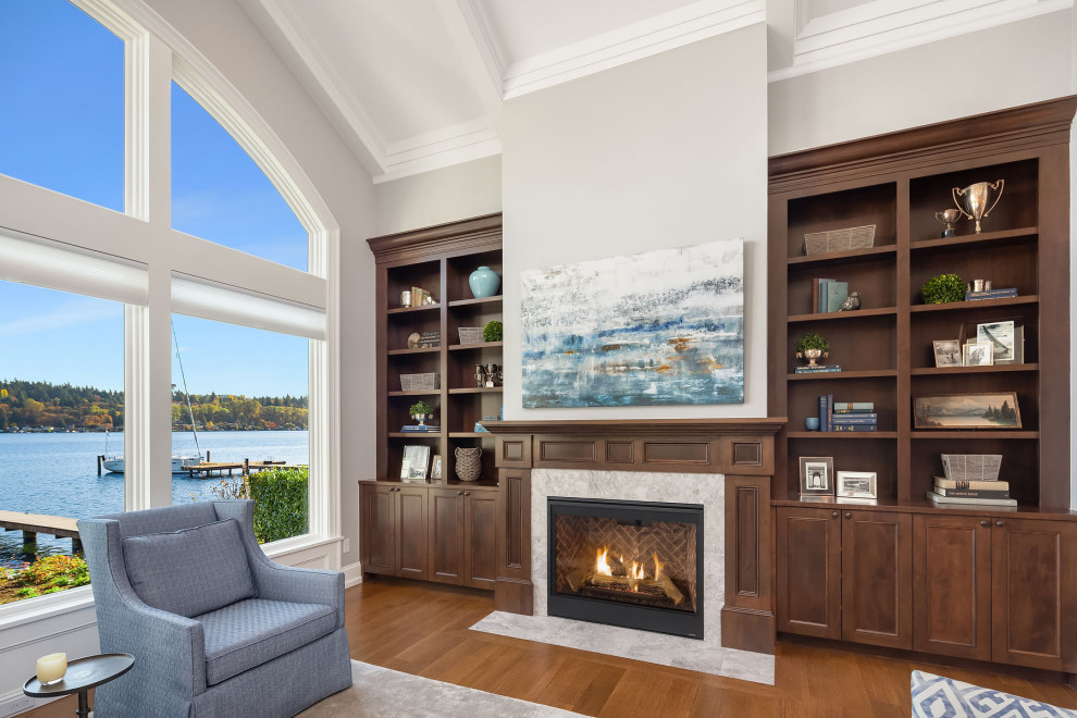 Mid-sized beach style open concept family room in Seattle with grey walls, medium hardwood floors, a stone fireplace surround, a concealed tv and brown floor.
