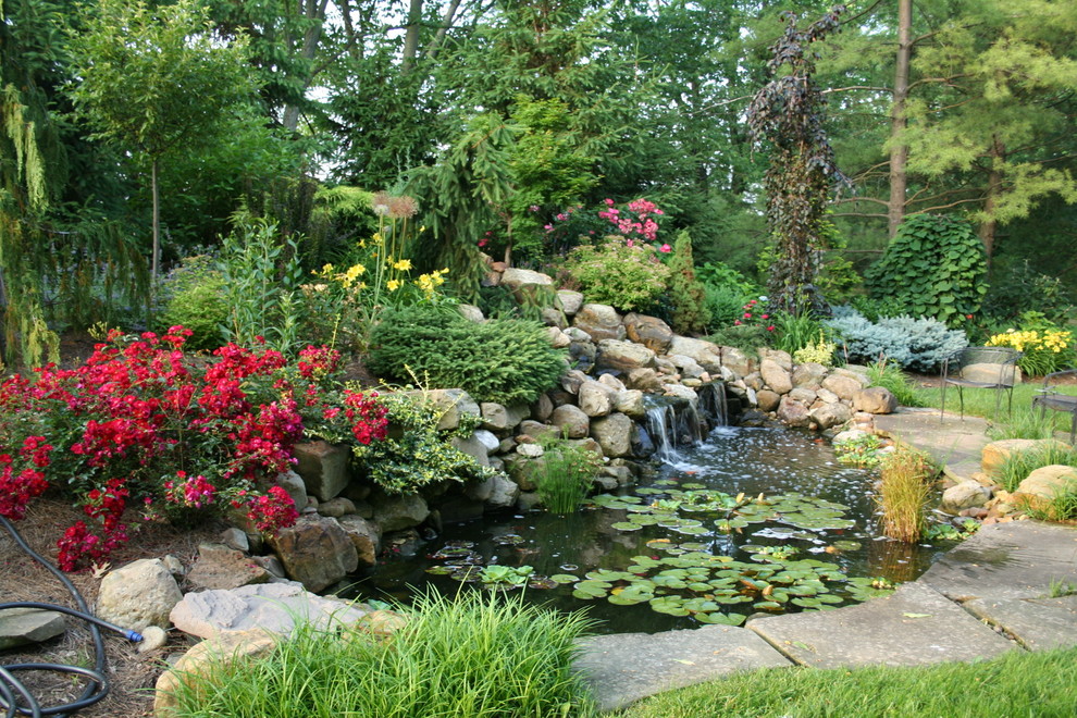 Inspiration for a large traditional backyard full sun formal garden for summer in Cincinnati with with pond and natural stone pavers.