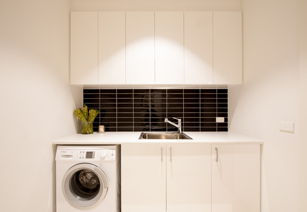 Photo of a small contemporary single-wall dedicated laundry room in Melbourne with a single-bowl sink, flat-panel cabinets, white cabinets, laminate benchtops, grey walls and porcelain floors.