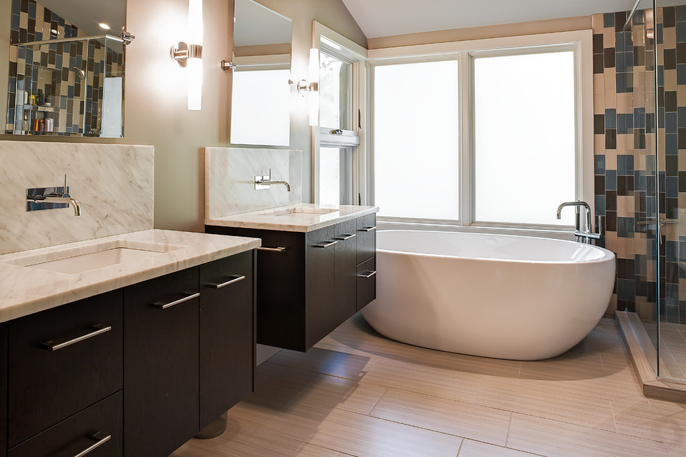 This is an example of a large contemporary master bathroom in Other with an undermount sink, flat-panel cabinets, black cabinets, marble benchtops, a freestanding tub, a corner shower, a two-piece toilet and beige walls.