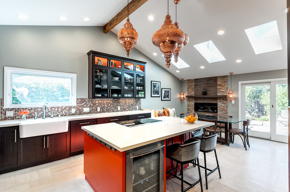 This is an example of a transitional eat-in kitchen in San Francisco with a farmhouse sink, shaker cabinets, dark wood cabinets, solid surface benchtops, mosaic tile splashback and with island.