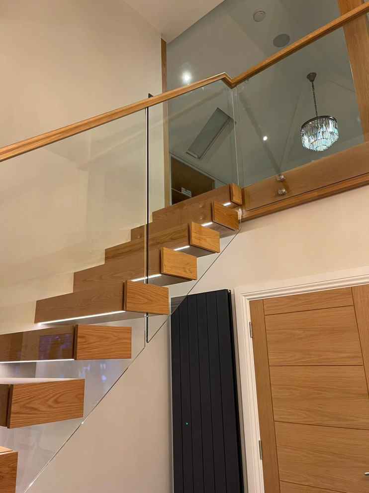 Imagen de escalera recta actual pequeña sin contrahuella con escalones de madera y barandilla de vidrio