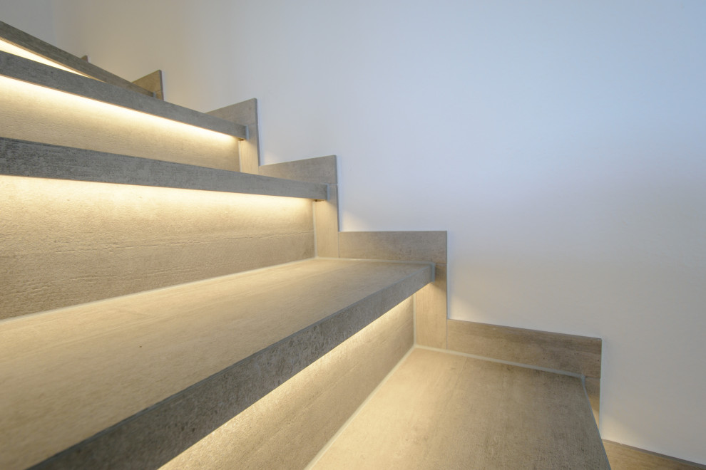 Gewendelte Moderne Treppe mit gefliesten Treppenstufen und gefliesten Setzstufen in Dortmund