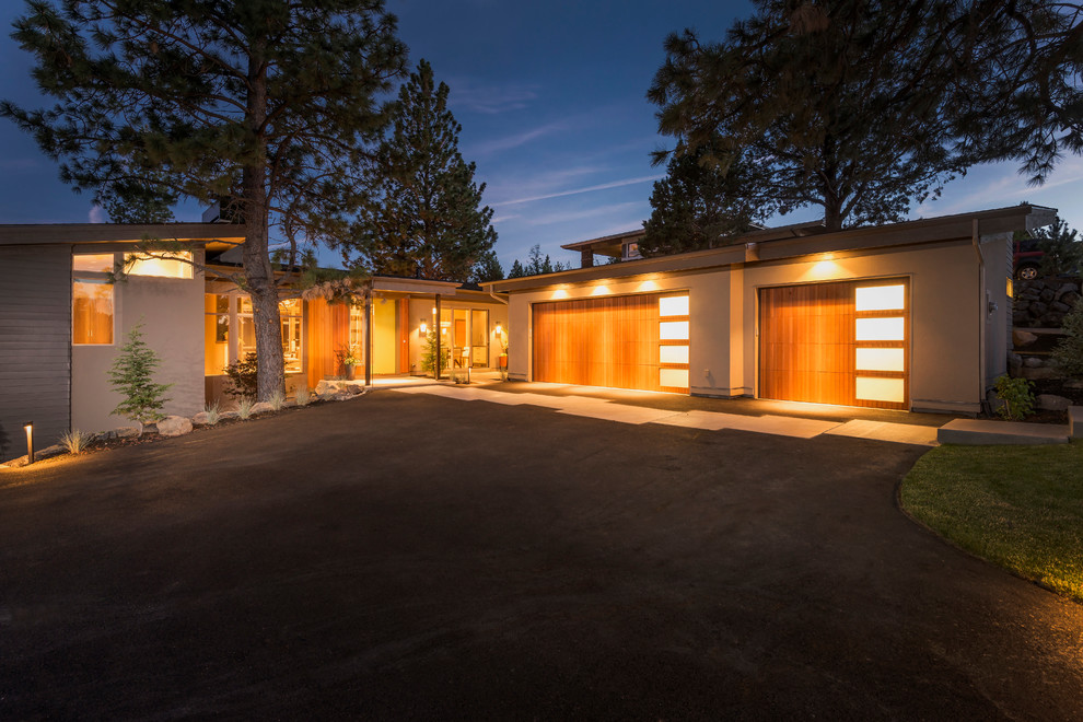 This is an example of a large contemporary attached three-car garage in Portland.