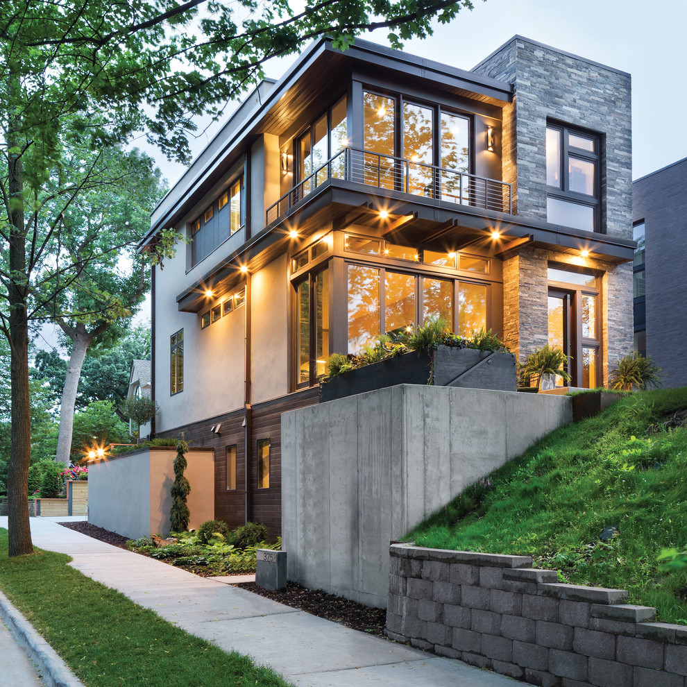 Design ideas for a large contemporary three-storey grey exterior in Minneapolis with mixed siding and a flat roof.