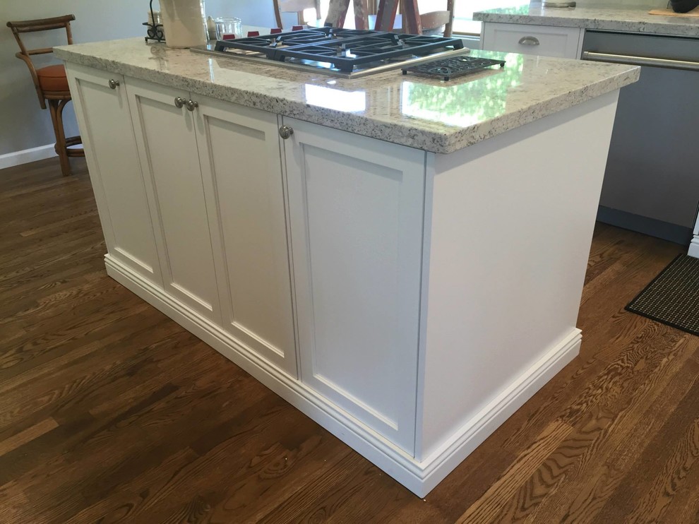 Example of a large transitional medium tone wood floor kitchen design in Phoenix with an undermount sink, shaker cabinets, white cabinets, granite countertops, white backsplash, subway tile backsplash, stainless steel appliances and an island