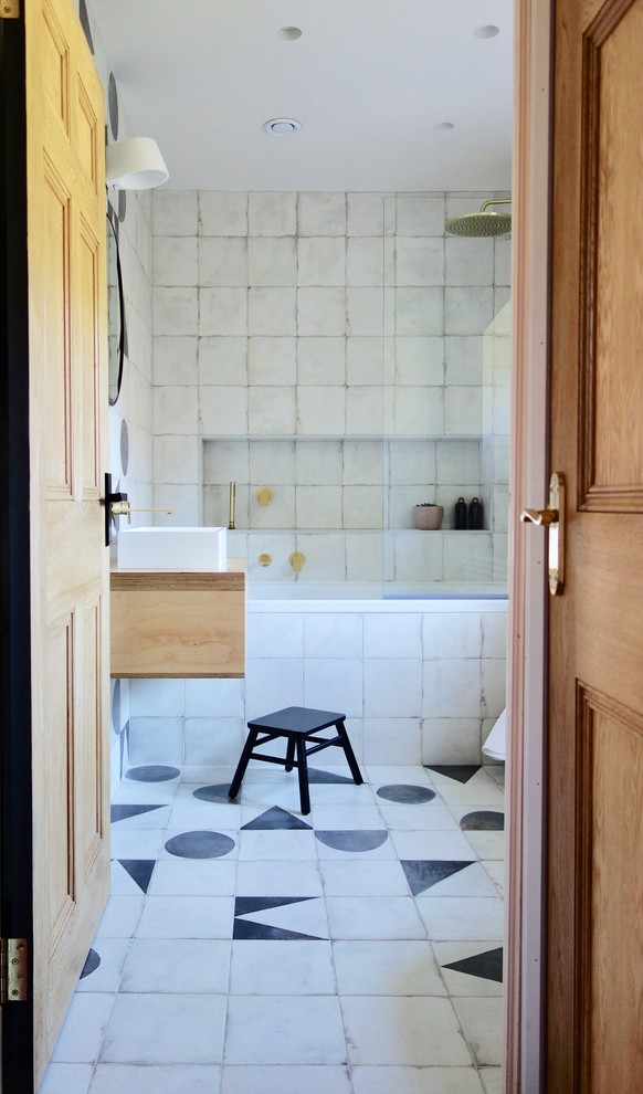 Scandinavian kids bathroom in Other with light wood cabinets, a drop-in tub, a shower/bathtub combo, a one-piece toilet, black and white tile, porcelain tile, white walls, porcelain floors, a console sink, wood benchtops and multi-coloured floor.