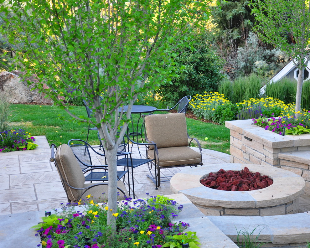 This is an example of a traditional backyard patio in Denver with a fire feature.