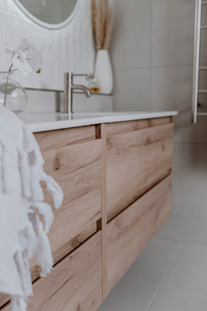Mid-sized contemporary master bathroom in Melbourne with furniture-like cabinets, light wood cabinets, an open shower, a one-piece toilet, gray tile, ceramic tile, grey walls, ceramic floors, an integrated sink, engineered quartz benchtops, grey floor, white benchtops, a shower seat, a double vanity and a floating vanity.