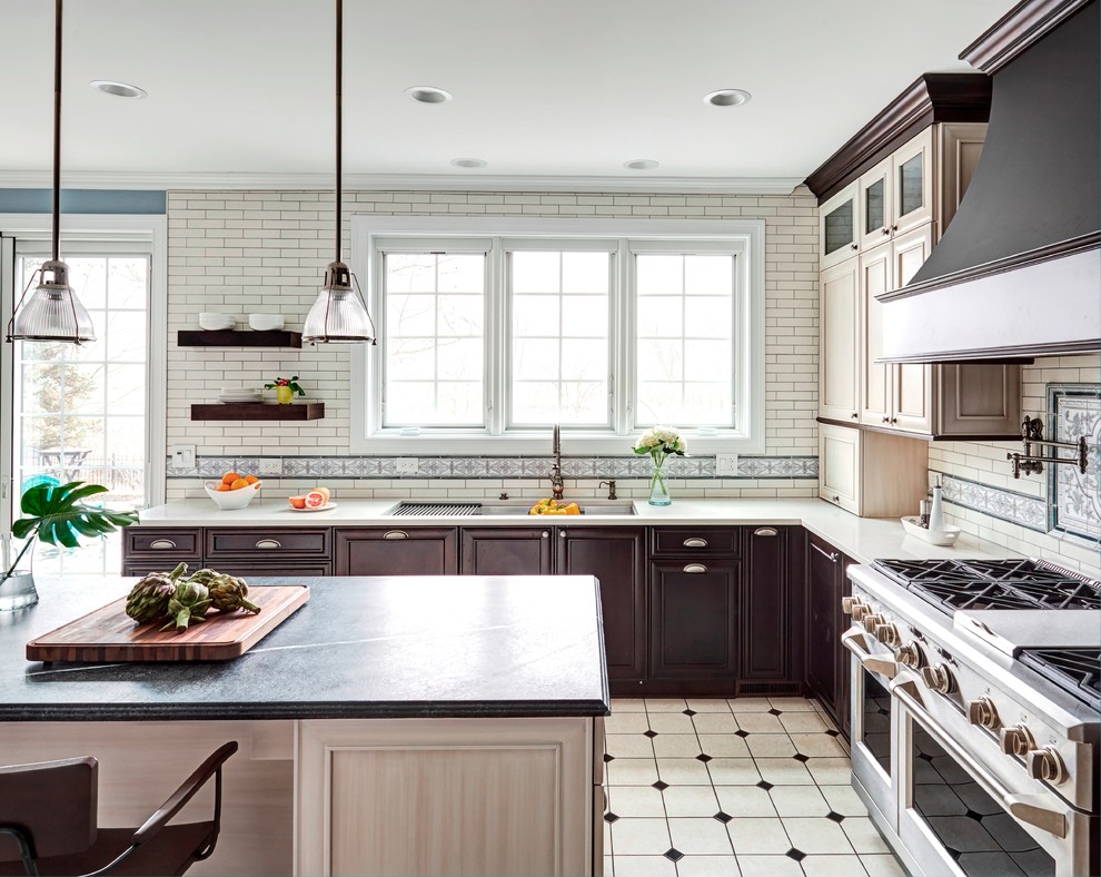 Design ideas for a large traditional u-shaped open plan kitchen in Chicago with a single-bowl sink, recessed-panel cabinets, dark wood cabinets, soapstone benchtops, white splashback, subway tile splashback, stainless steel appliances, ceramic floors, with island, white floor and grey benchtop.