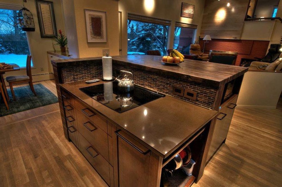 Example of a transitional l-shaped light wood floor eat-in kitchen design with flat-panel cabinets, medium tone wood cabinets, quartz countertops, brown backsplash, mosaic tile backsplash, black appliances and an island