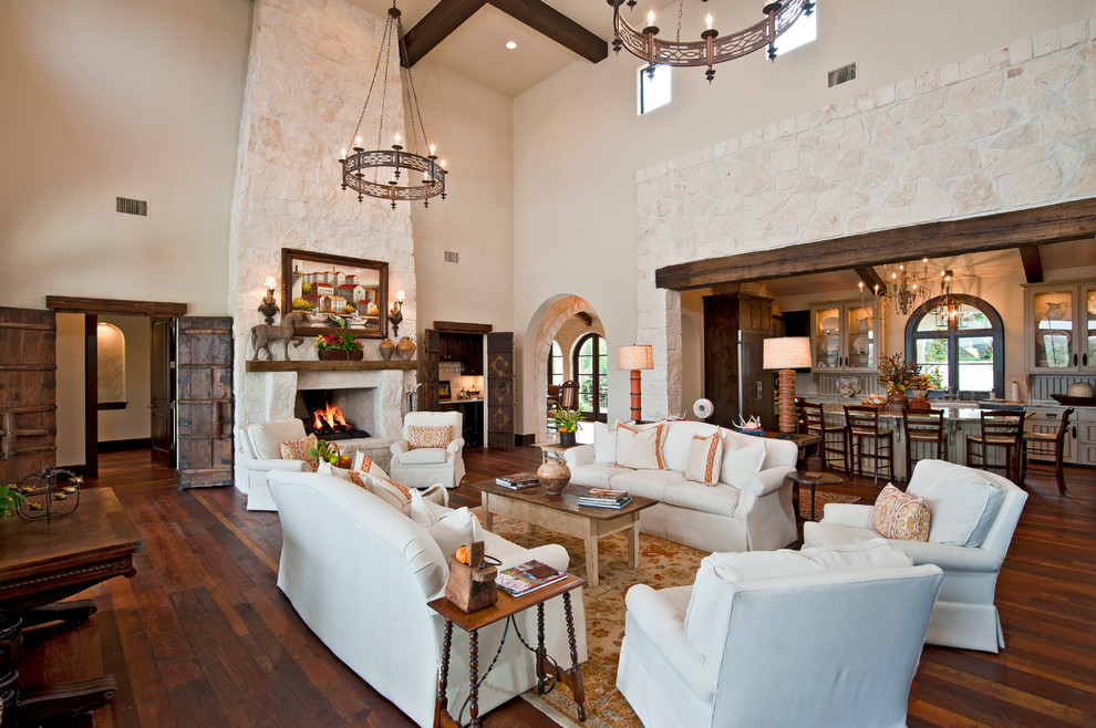 Expansive mediterranean formal open concept living room in Austin with white walls, medium hardwood floors, a standard fireplace and a stone fireplace surround.