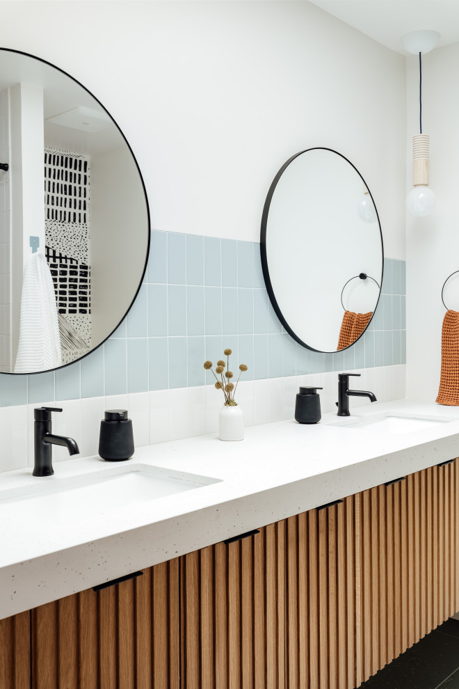 Foto di una stanza da bagno con ante in legno scuro, vasca/doccia, piastrelle blu, pavimento alla veneziana, lavabo sottopiano, pavimento verde, top grigio e due lavabi