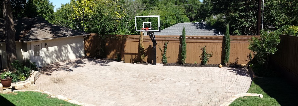 This is an example of a large traditional backyard partial sun outdoor sport court in Austin with brick pavers.
