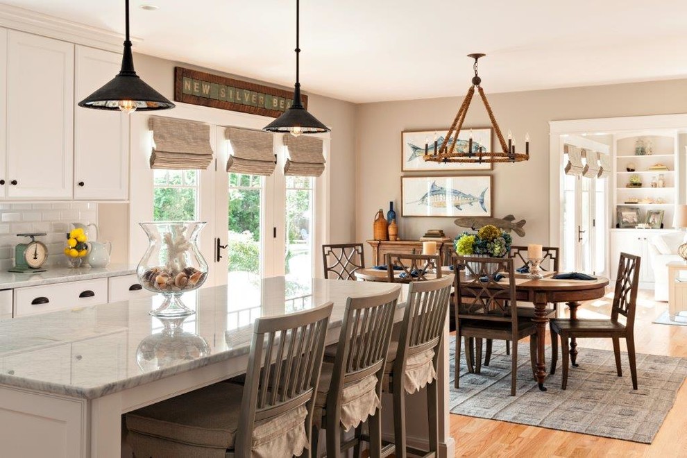 Example of a mid-sized transitional l-shaped light wood floor and beige floor eat-in kitchen design in Boston with recessed-panel cabinets, white cabinets, granite countertops, white backsplash, subway tile backsplash, stainless steel appliances, an island and a farmhouse sink