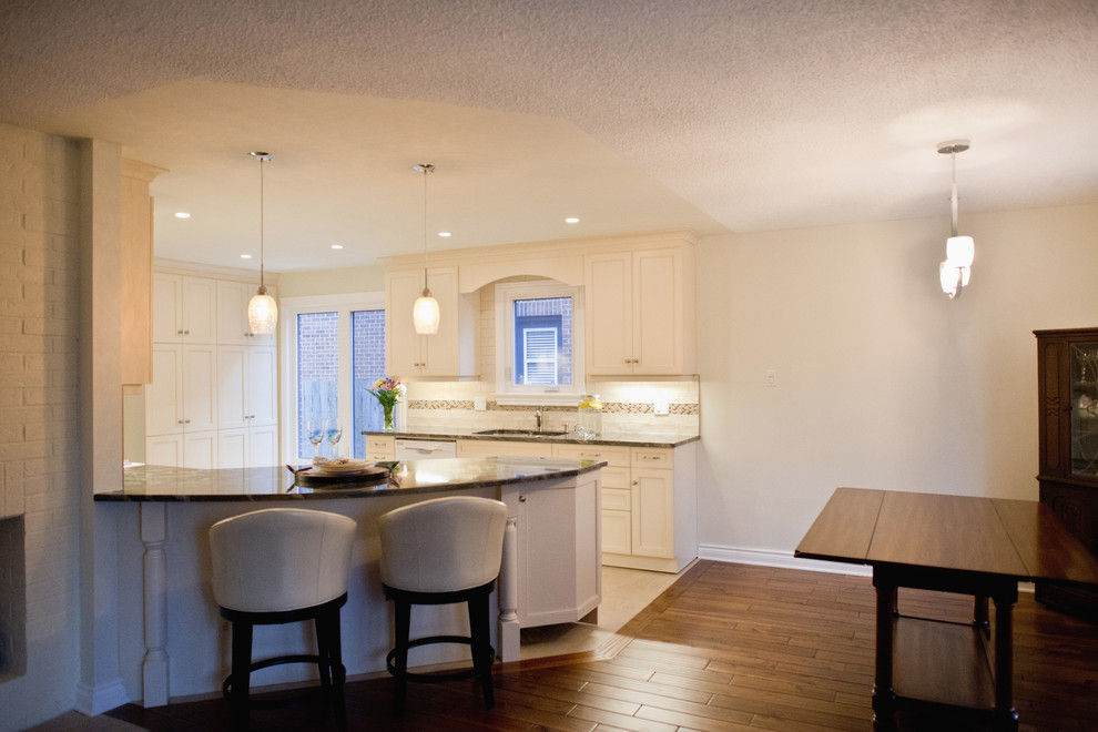 Inspiration for a mid-sized transitional ceramic tile eat-in kitchen remodel in Ottawa with granite countertops, ceramic backsplash and an island