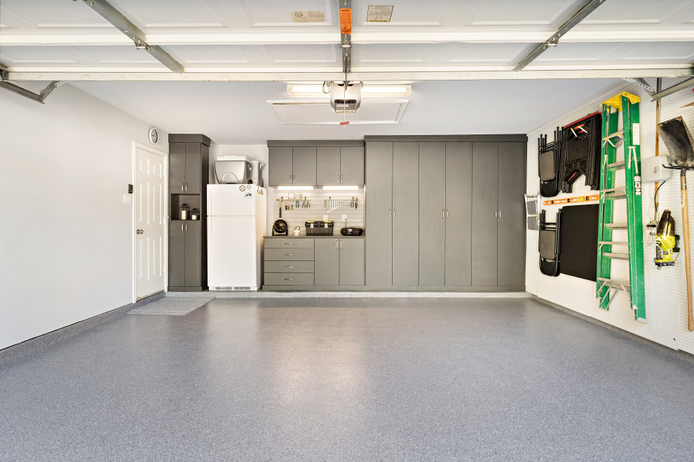 Cette photo montre un garage pour deux voitures attenant de taille moyenne avec un bureau, studio ou atelier.