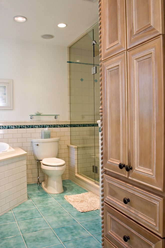 This is an example of a mid-sized beach style master bathroom in Bridgeport with an undermount sink, medium wood cabinets, engineered quartz benchtops, a corner tub, an alcove shower, a two-piece toilet, beige tile, ceramic tile, white walls, porcelain floors and recessed-panel cabinets.