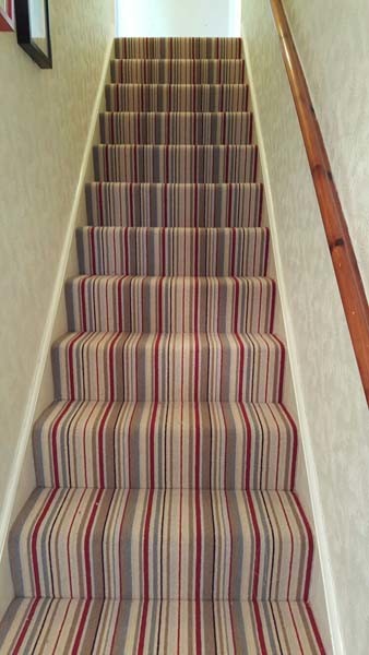 Inspiration for a mid-sized transitional carpeted u-shaped staircase in London with carpet risers.