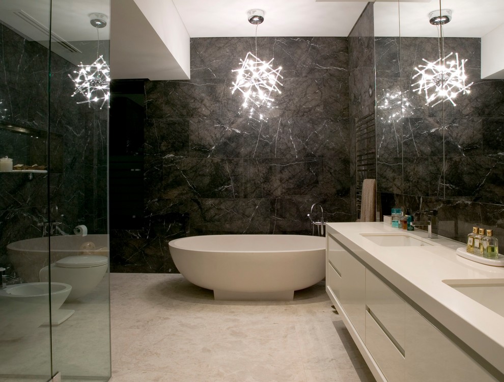 This is an example of a large contemporary master bathroom in Melbourne with an undermount sink, flat-panel cabinets, white cabinets, granite benchtops, a freestanding tub, beige tile, stone tile, black walls and travertine floors.