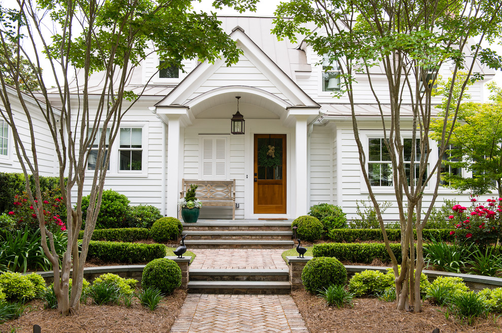 Photo of a traditional front door in Charleston with white walls, a single front door and a brown front door.