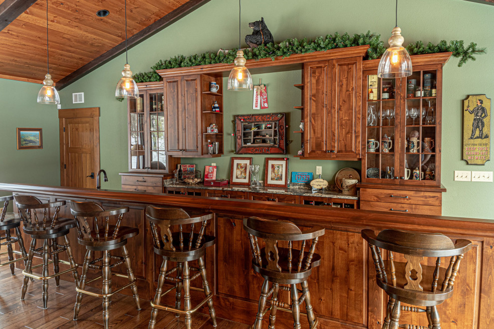 Design ideas for a country galley home bar in Other with medium hardwood floors, raised-panel cabinets, medium wood cabinets, wood benchtops, brown floor and brown benchtop.