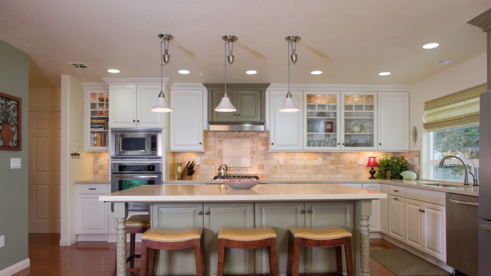 Open concept kitchen - mid-sized transitional l-shaped medium tone wood floor open concept kitchen idea with a double-bowl sink, raised-panel cabinets, white cabinets, white backsplash, stainless steel appliances and an island