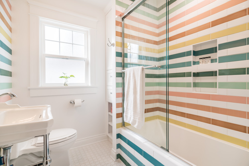 Design ideas for a mid-sized transitional kids bathroom in Portland with white cabinets, an alcove tub, a shower/bathtub combo, multi-coloured tile, ceramic tile, multi-coloured walls, white floor, a sliding shower screen, a niche and a single vanity.