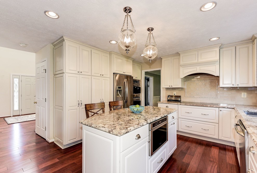 Mid-sized transitional u-shaped medium tone wood floor and brown floor eat-in kitchen photo in Baltimore with an undermount sink, raised-panel cabinets, white cabinets, granite countertops, beige backsplash, porcelain backsplash, stainless steel appliances and an island