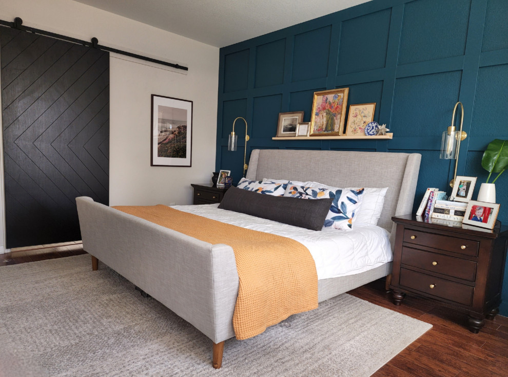 Modelo de dormitorio principal tradicional renovado de tamaño medio con paredes azules, suelo de madera en tonos medios y suelo marrón