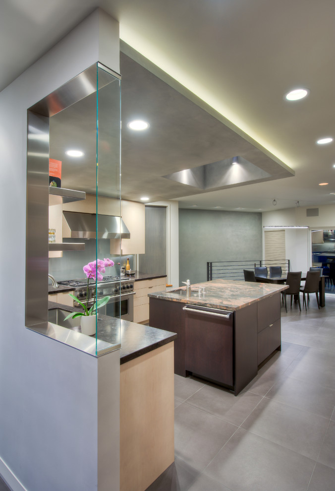 Photo of a large contemporary l-shaped eat-in kitchen in San Francisco with an undermount sink, flat-panel cabinets, dark wood cabinets, granite benchtops, glass sheet splashback, stainless steel appliances, porcelain floors, with island and grey splashback.