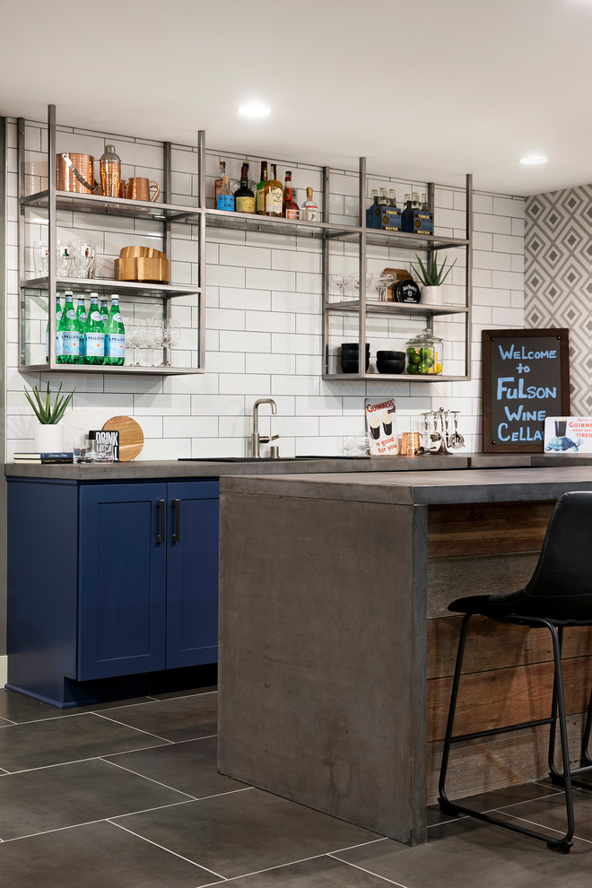 Modern seated home bar in Minneapolis with an undermount sink, shaker cabinets, blue cabinets, concrete benchtops, white splashback, ceramic splashback, porcelain floors, grey floor and grey benchtop.