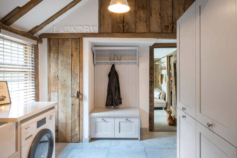 Design ideas for a large classic galley utility room in Kent with a belfast sink, shaker cabinets, white cabinets, quartz worktops, white walls, grey floors and white worktops.