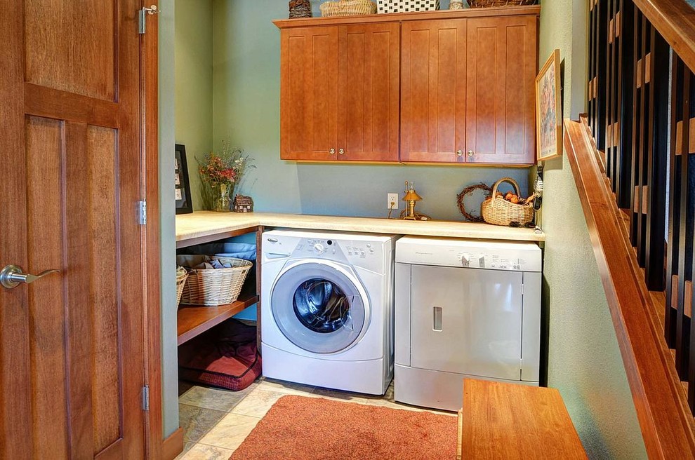 Design ideas for a contemporary u-shaped dedicated laundry room in Milwaukee with recessed-panel cabinets, medium wood cabinets, laminate benchtops, green walls, ceramic floors and a side-by-side washer and dryer.