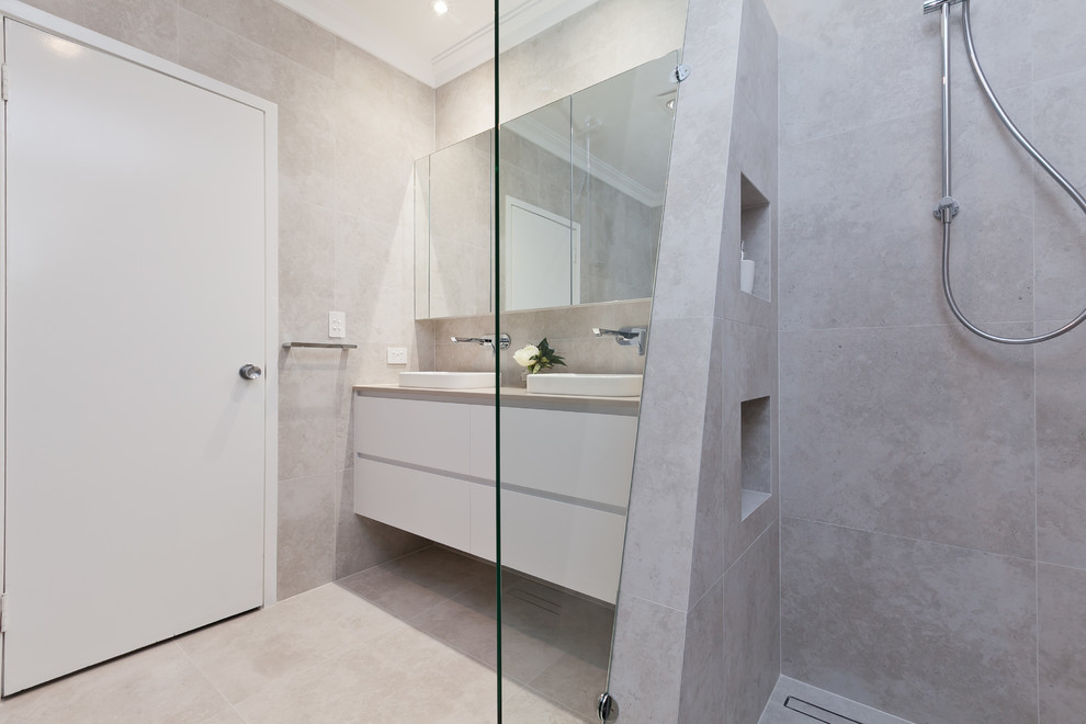 Design ideas for a mid-sized contemporary master bathroom in Perth with flat-panel cabinets, white cabinets, a drop-in tub, an open shower, a one-piece toilet, beige tile, porcelain tile, a drop-in sink, engineered quartz benchtops, an open shower and beige benchtops.