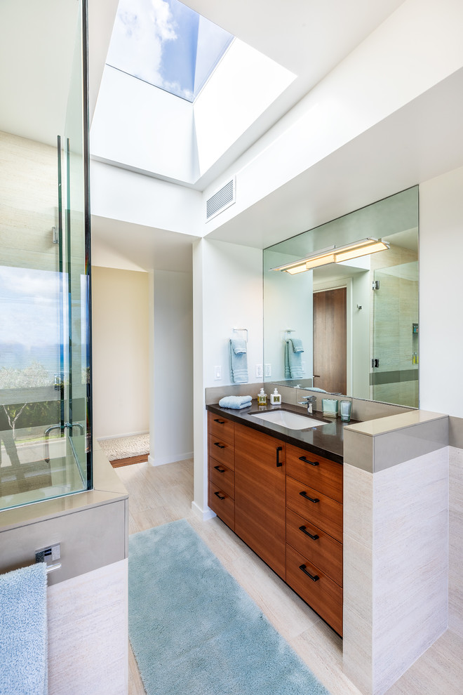 Large modern master bathroom in Hawaii with flat-panel cabinets, medium wood cabinets, an alcove shower, beige tile, porcelain tile, porcelain floors, an undermount sink, granite benchtops, beige floor and a hinged shower door.