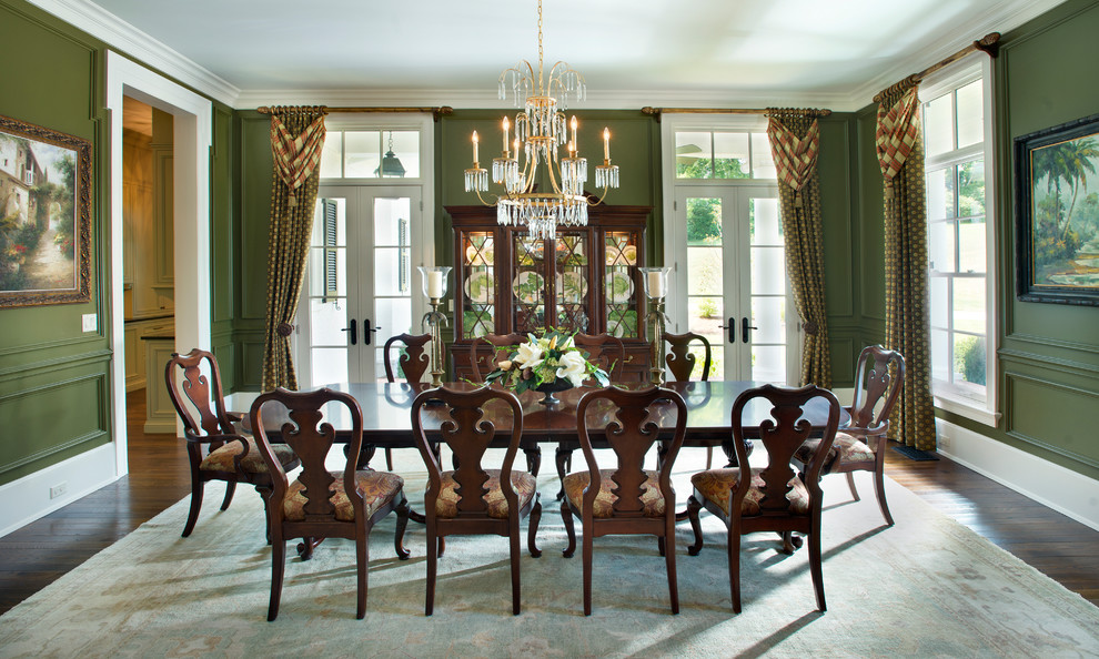 This is an example of a traditional separate dining room in Nashville with green walls and dark hardwood floors.
