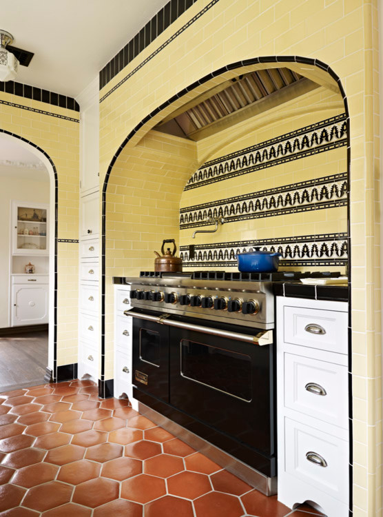 Photo of a mid-sized mediterranean separate kitchen in Los Angeles with recessed-panel cabinets, white cabinets, tile benchtops, yellow splashback, subway tile splashback, coloured appliances, terra-cotta floors, red floor, multi-coloured benchtop, a farmhouse sink and no island.