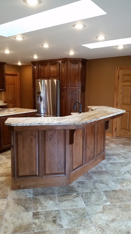 Large elegant u-shaped ceramic tile kitchen photo with a farmhouse sink, raised-panel cabinets, medium tone wood cabinets, granite countertops, stainless steel appliances and two islands