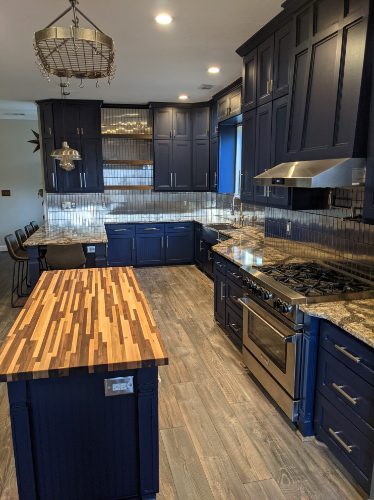 Design ideas for an eclectic eat-in kitchen in Houston with a farmhouse sink, shaker cabinets, quartz benchtops, metallic splashback, stainless steel appliances, vinyl floors and multiple islands.