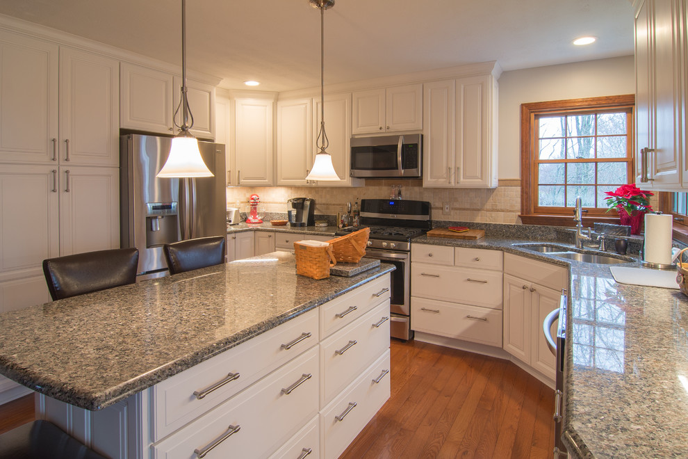 Photo of a traditional eat-in kitchen in Other with white cabinets, glass tile splashback, raised-panel cabinets, granite benchtops and with island.