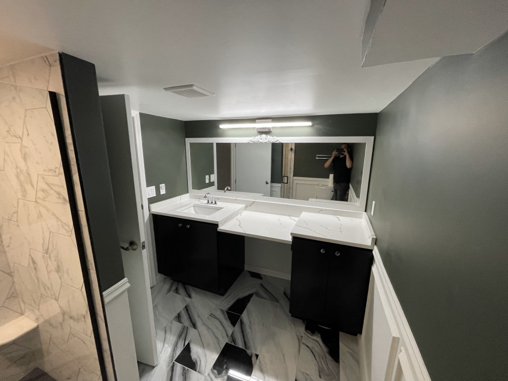 This is an example of a medium sized victorian ensuite bathroom in Detroit with flat-panel cabinets, black cabinets, an alcove shower, a two-piece toilet, white tiles, ceramic tiles, green walls, cement flooring, a submerged sink, engineered stone worktops, black floors, a hinged door, a single sink and a built in vanity unit.