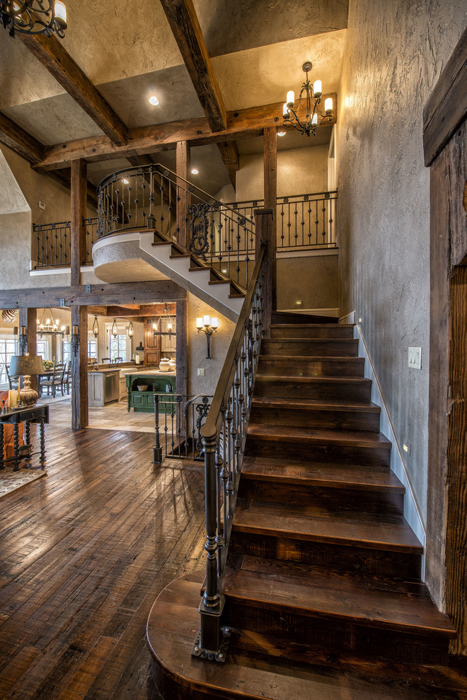 This is an example of a large country wood l-shaped staircase in Other with wood risers and metal railing.