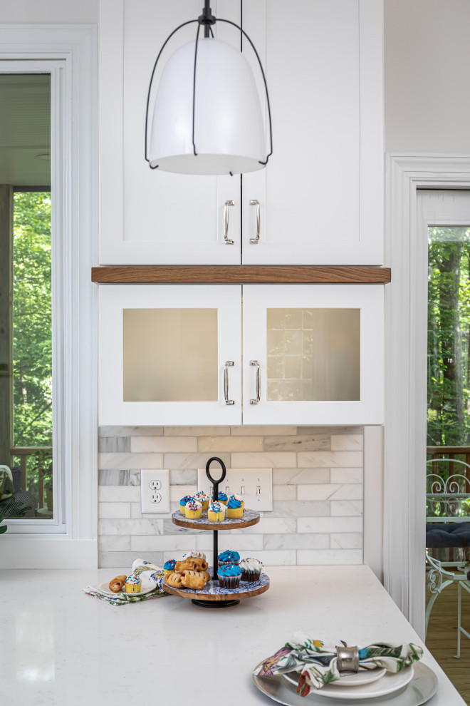 Mid-sized transitional l-shaped medium tone wood floor and brown floor eat-in kitchen photo in Raleigh with an undermount sink, shaker cabinets, blue cabinets, quartzite countertops, white backsplash, marble backsplash, stainless steel appliances, an island and white countertops