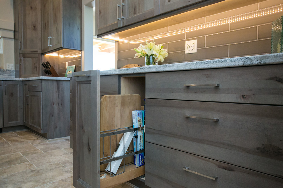 Inspiration for a small rustic l-shaped ceramic tile home design remodel in Phoenix with an undermount sink, flat-panel cabinets, gray cabinets, granite countertops, gray backsplash, ceramic backsplash, stainless steel appliances and an island