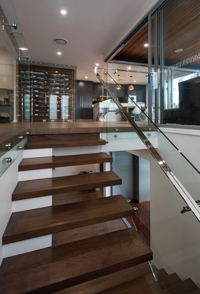 This is an example of a contemporary wood u-shaped staircase in Brisbane with wood risers and glass railing.