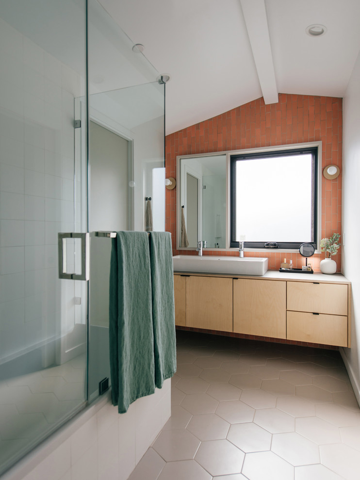 Inspiration for a small beach style master bathroom in Orange County with light wood cabinets, a corner tub, a shower/bathtub combo, ceramic tile, porcelain floors, a vessel sink, wood benchtops, beige floor, a hinged shower door, grey benchtops, flat-panel cabinets, orange tile, red tile and white walls.