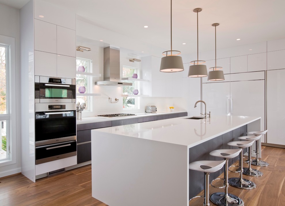 Design ideas for a contemporary l-shaped kitchen in Miami with flat-panel cabinets, white cabinets, white splashback, medium hardwood floors and with island.