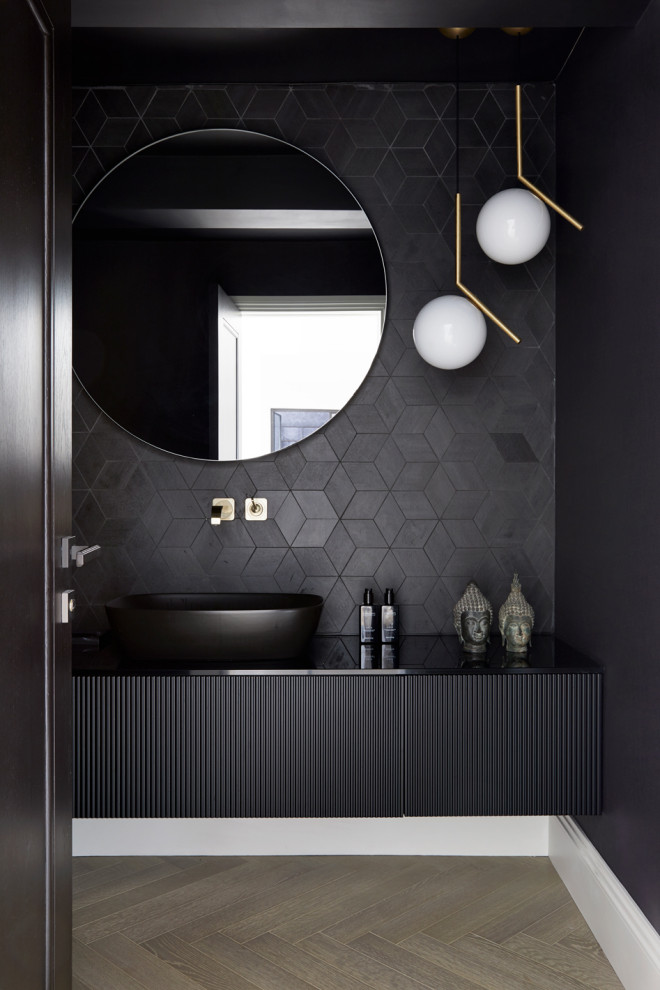 Design ideas for a mid-sized powder room in London with beaded inset cabinets, black cabinets, a wall-mount toilet, black tile, ceramic tile, black walls, light hardwood floors, a pedestal sink, concrete benchtops, beige floor, black benchtops, a floating vanity, recessed and wallpaper.